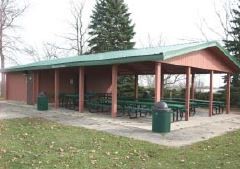 Park shelter with picnic tables in a wooded area